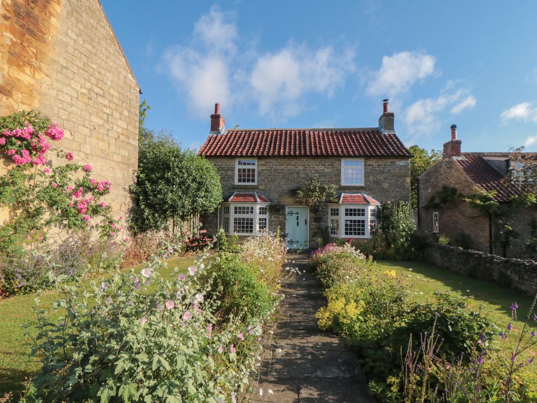A house with a garden and pathway at Bute Cottage in Lockton near Pickering