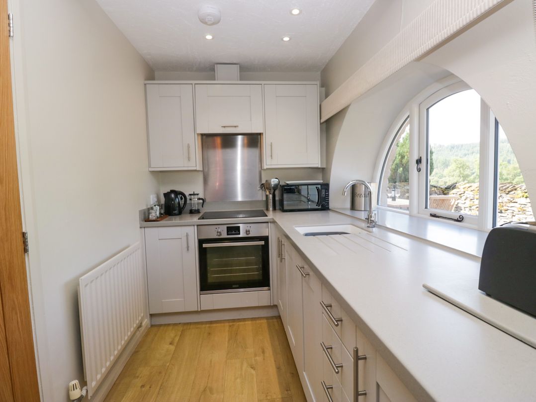 A kitchen with an oven and microwave at Windermere at the Graythwaite Estate near Hawkshead