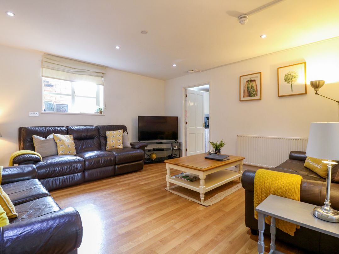 A living room with a sofa and television at BB House Roxhill Manor Farm