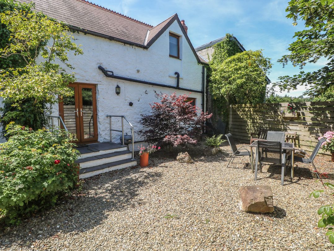 A garden with steps, table and chairs at Stable Cottage, Narberth