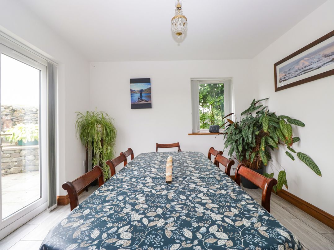 A dining room with a long table and chairs at Sherriff, Troutbeck, near Keswick
