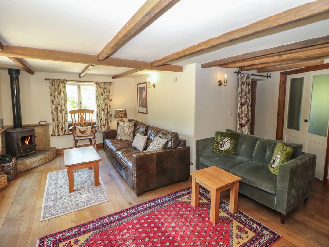 A living room with a fireplace and seating at Green Farm Stables in Hognaston near Carsington Water