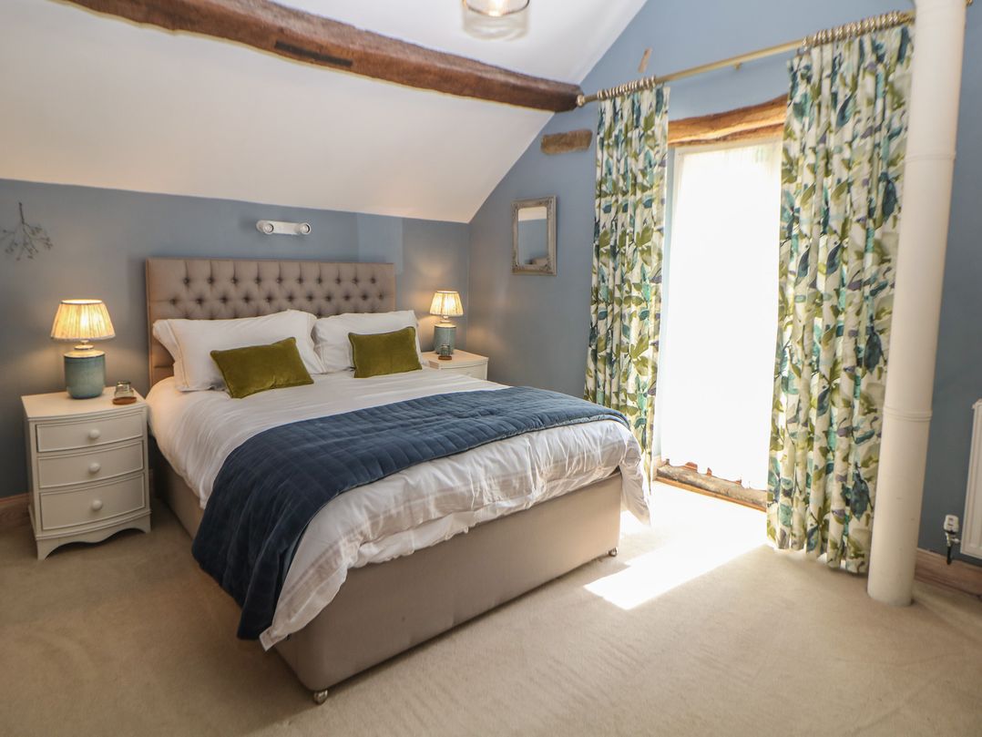 A bedroom with a bed and bedside tables at Green Farm Stables Hognaston near Carsington Water