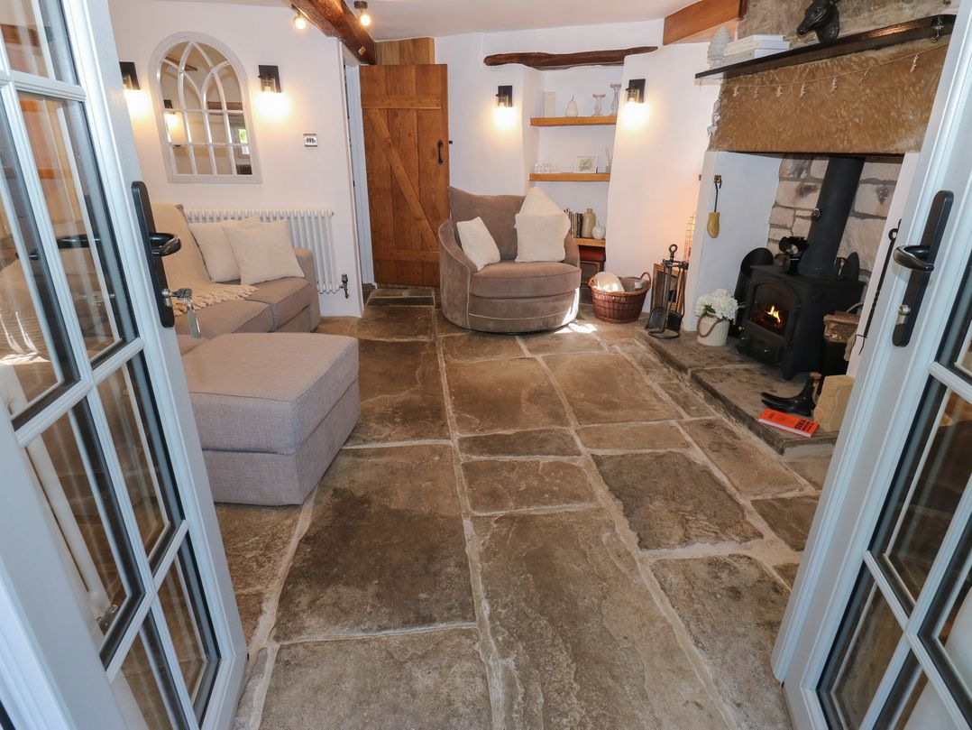 A living room with a sofa and fireplace at Lydgate Cottage in Eyam