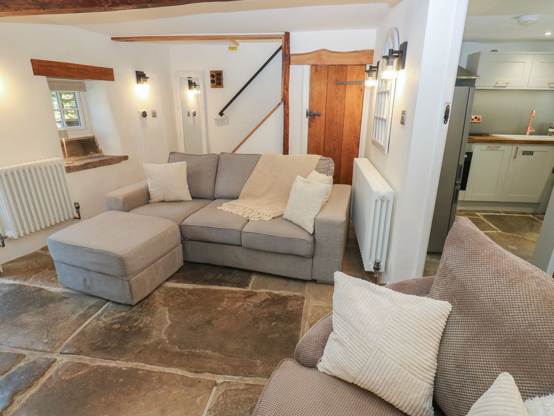 A living room with a sofa and radiator at Lydgate Cottage in Eyam