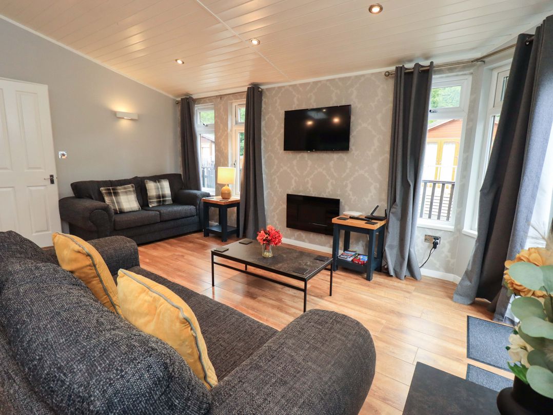 A living room with a television and sofas at Rydal Lodge Grasmere 24, White Cross Bay near Windermere