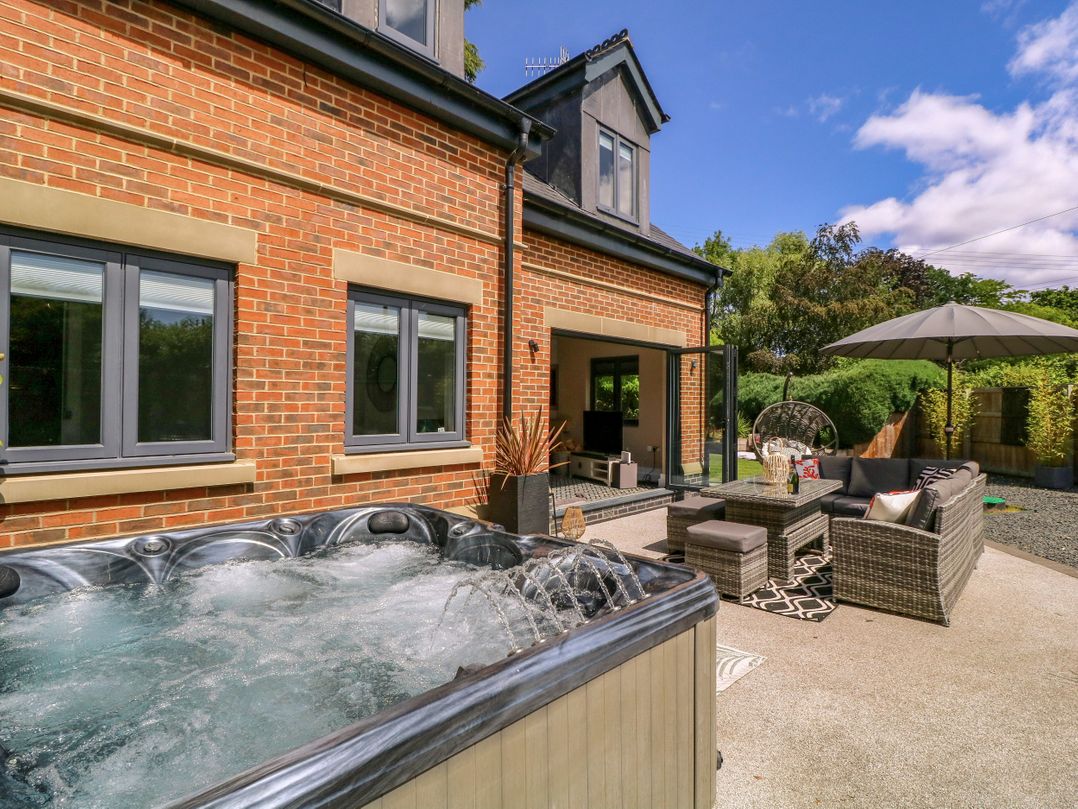 An outdoor space with a hot tub and seating area at Thornbury, Barnard's Green, Malvern