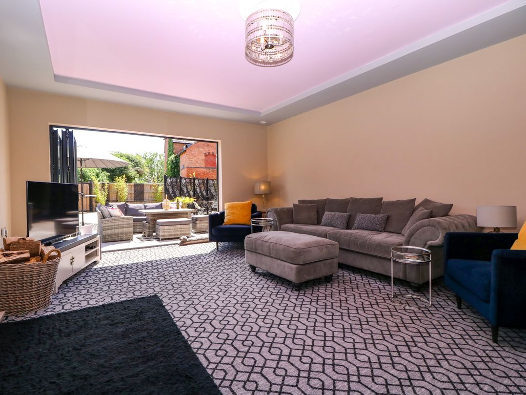 A living room with a sofa and television at Thornbury, Barnard's Green, Malvern