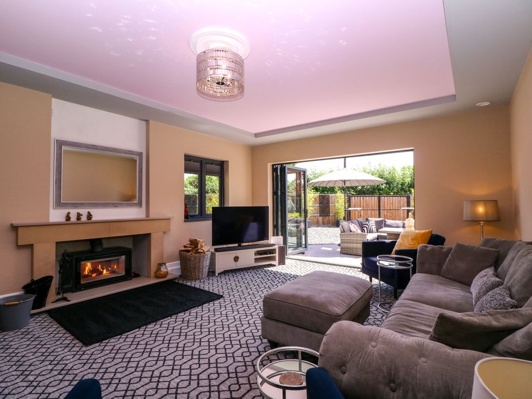 A living room with a television and fireplace at Thornbury in Barnard's Green, Malvern