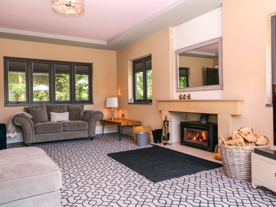 A living room with a sofa, table, and fireplace at Thornbury in Barnard's Green, Malvern