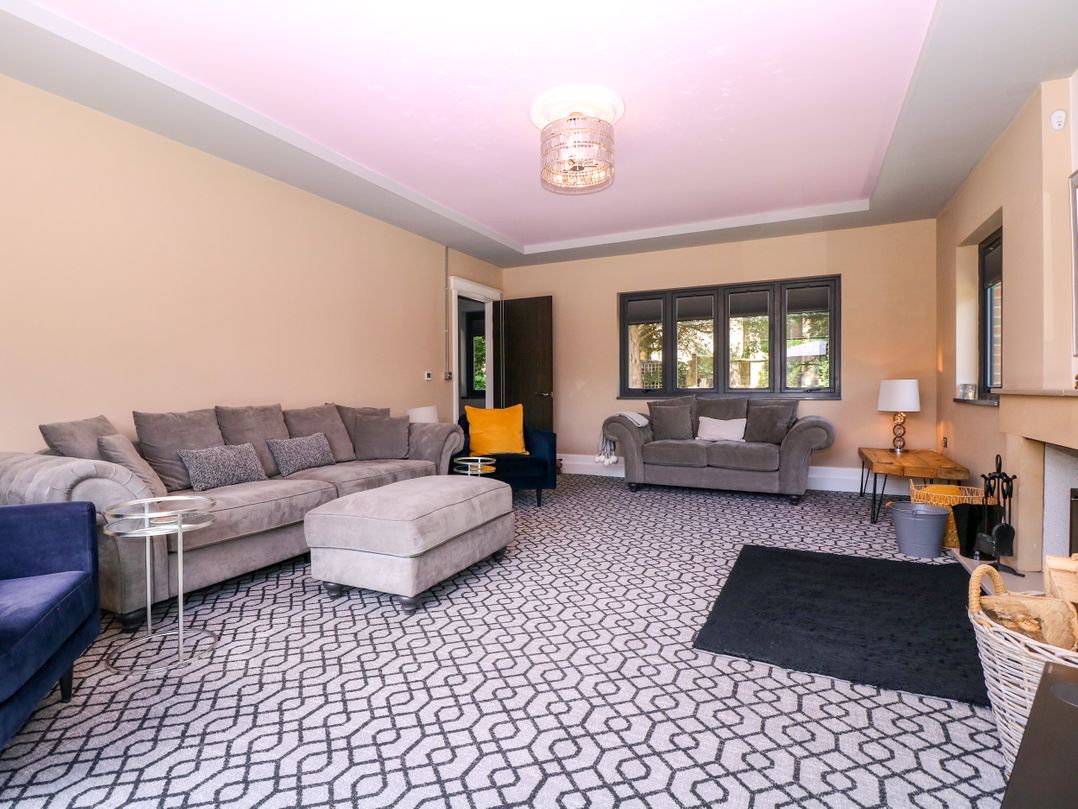 A living room with furniture arranged around a coffee table at Thornbury, Barnard's Green, Malvern