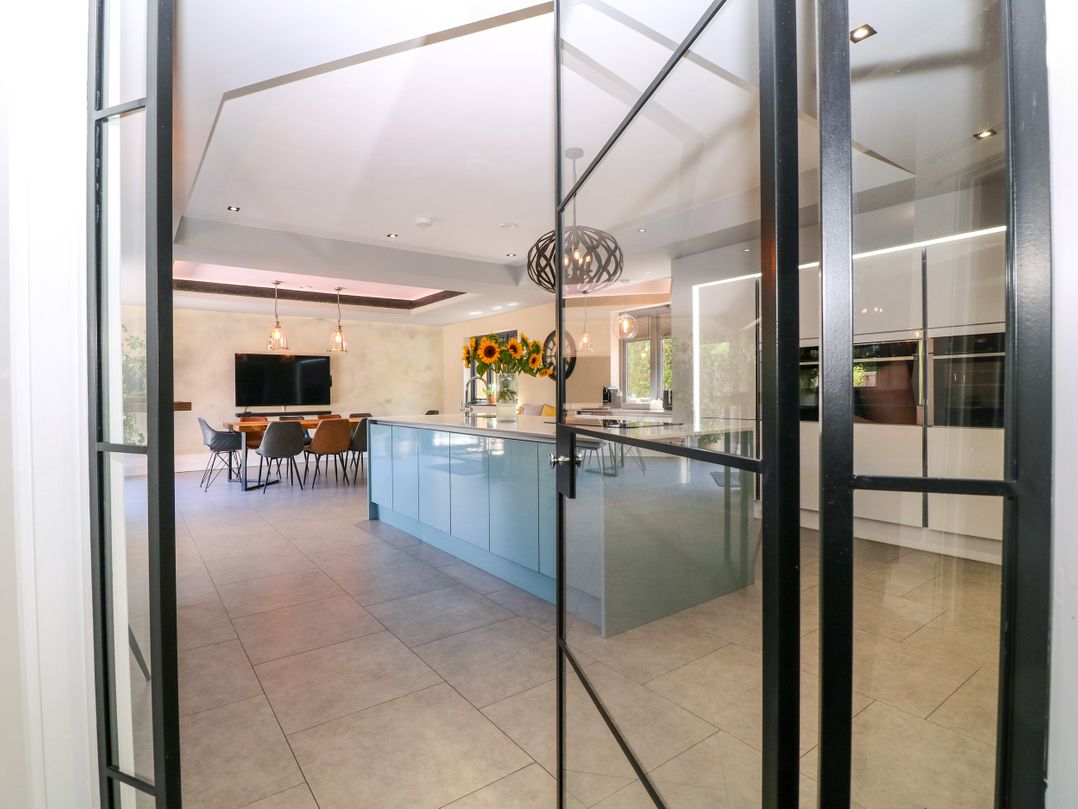 A kitchen with an island and dining area at Thornbury in Barnard's Green, Malvern