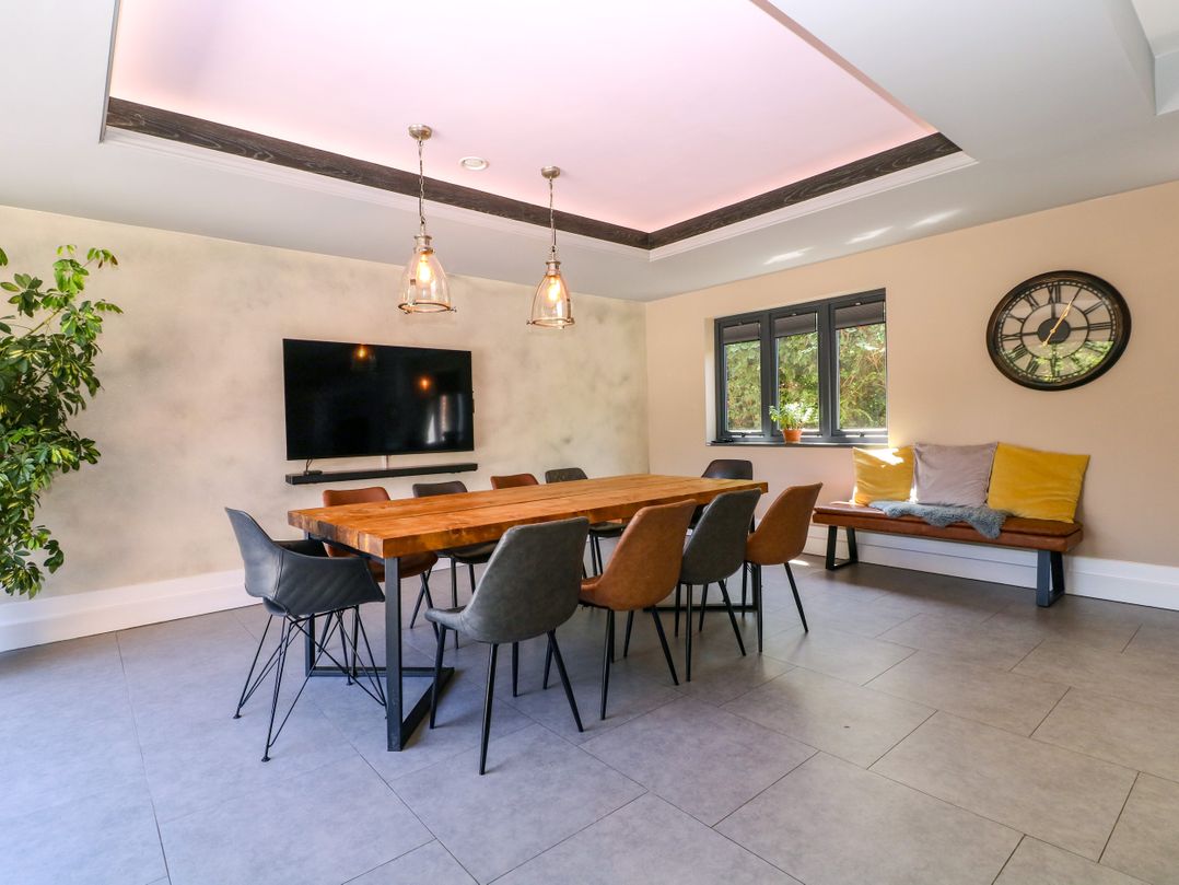 A dining room with a wooden table and chairs at Thornbury, Barnard's Green, Malvern