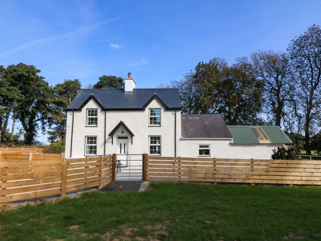 A house with a fence and gate at Gate House Capel Coch near Llanerchymedd