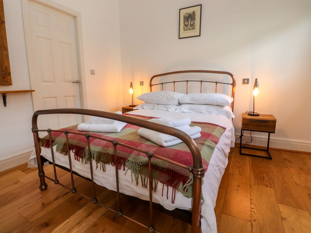 A bedroom with a bed and bedside table at The Stables in Hall Green near Walmer Bridge