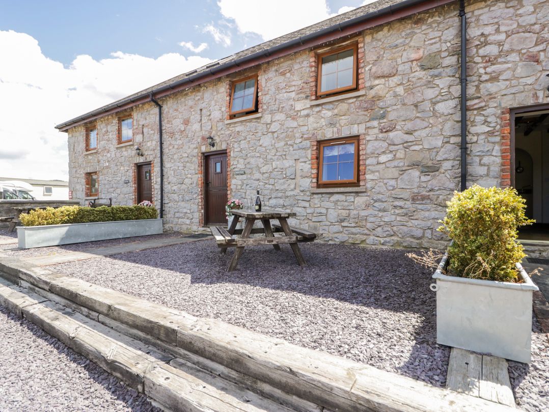 An outdoor area with a table and planters at Bwthyn Y Wennol in Dolwen near Abergele