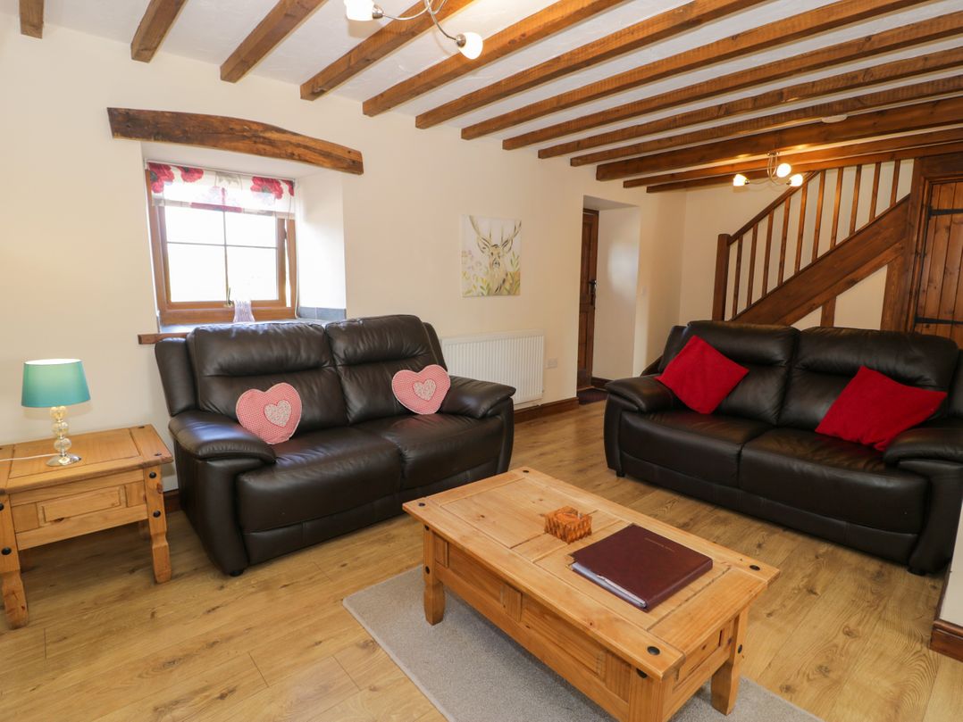 A living room with sofas and a coffee table at Bwthyn Y Wennol Dolwen near Abergele