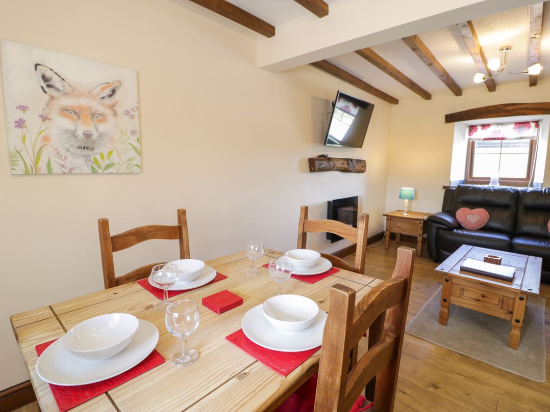 A dining room with table set for meals at Bwthyn Y Wennol in Dolwen near Abergele
