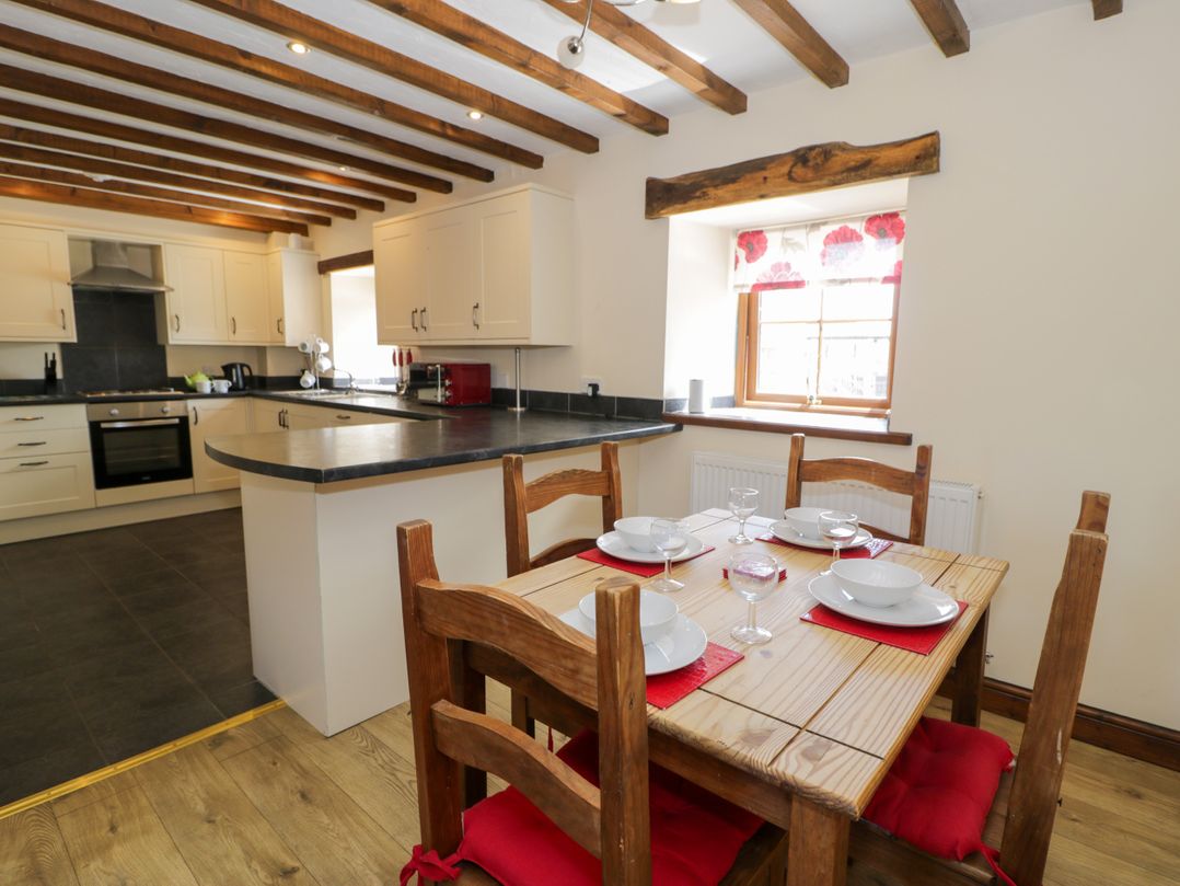 A kitchen with a dining table and chairs at Bwthyn Y Wennol Dolwen near Abergele