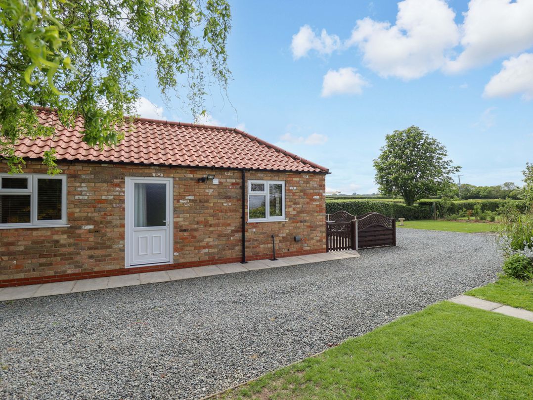 An outdoor view of a house with a gravel driveway and garden at The New Build in South Reston near Louth