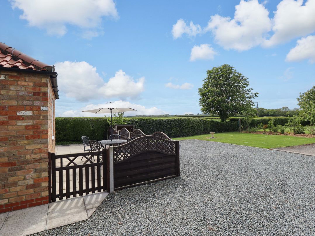 An outdoor space with a table and chairs near a hedge at The New Build in South Reston near Louth