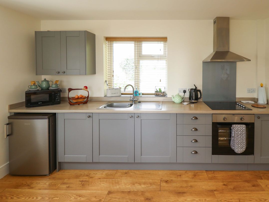 A kitchen with cabinets, sink, stove, microwave, and fruit bowl at The New Build in South Reston near Louth