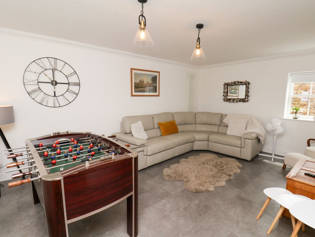 A living room with a foosball table and sofa at Fell Briggs Cottage in Marske-By-The-Sea