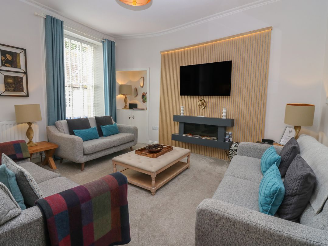 A living room with a television and coffee table at 2 Abbey Row in Kelso