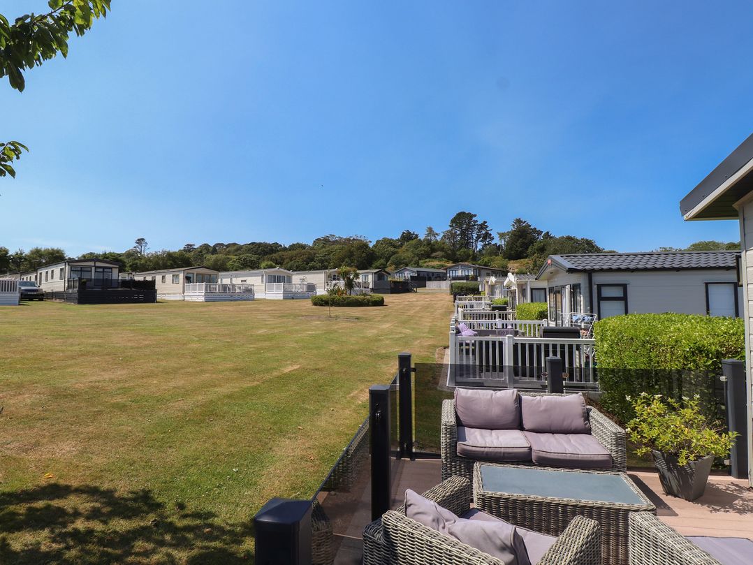 An outdoor area with caravans and patio furniture at 97 Crugan Llanbedrog