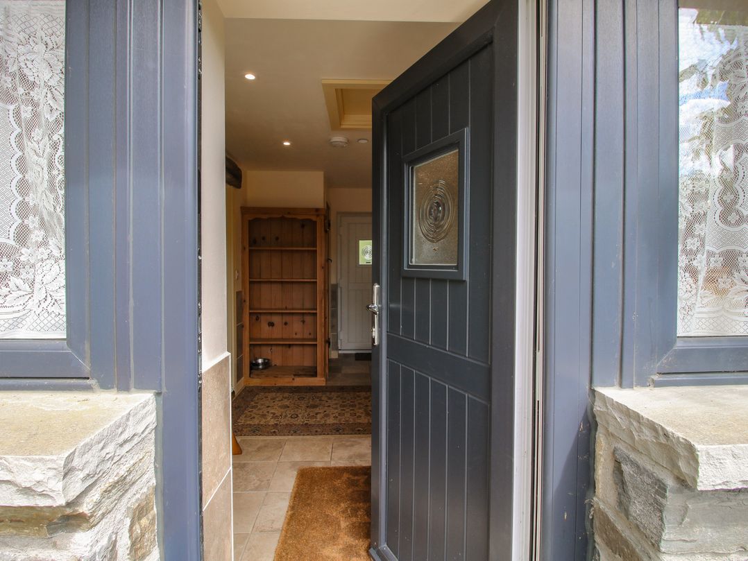 An entrance with a front door and shelving unit at Buzzards Breg in Builth Wells