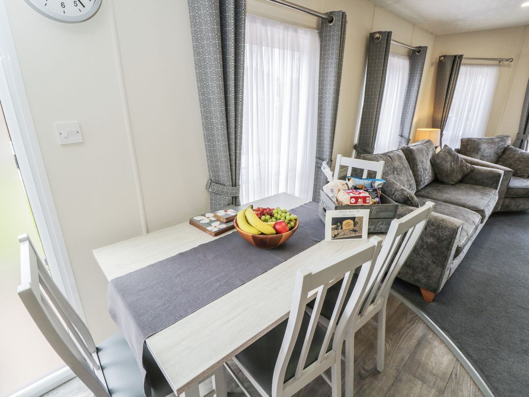 A dining area with a table and fruit at The Cotswold Holiday Lodge in Evesham