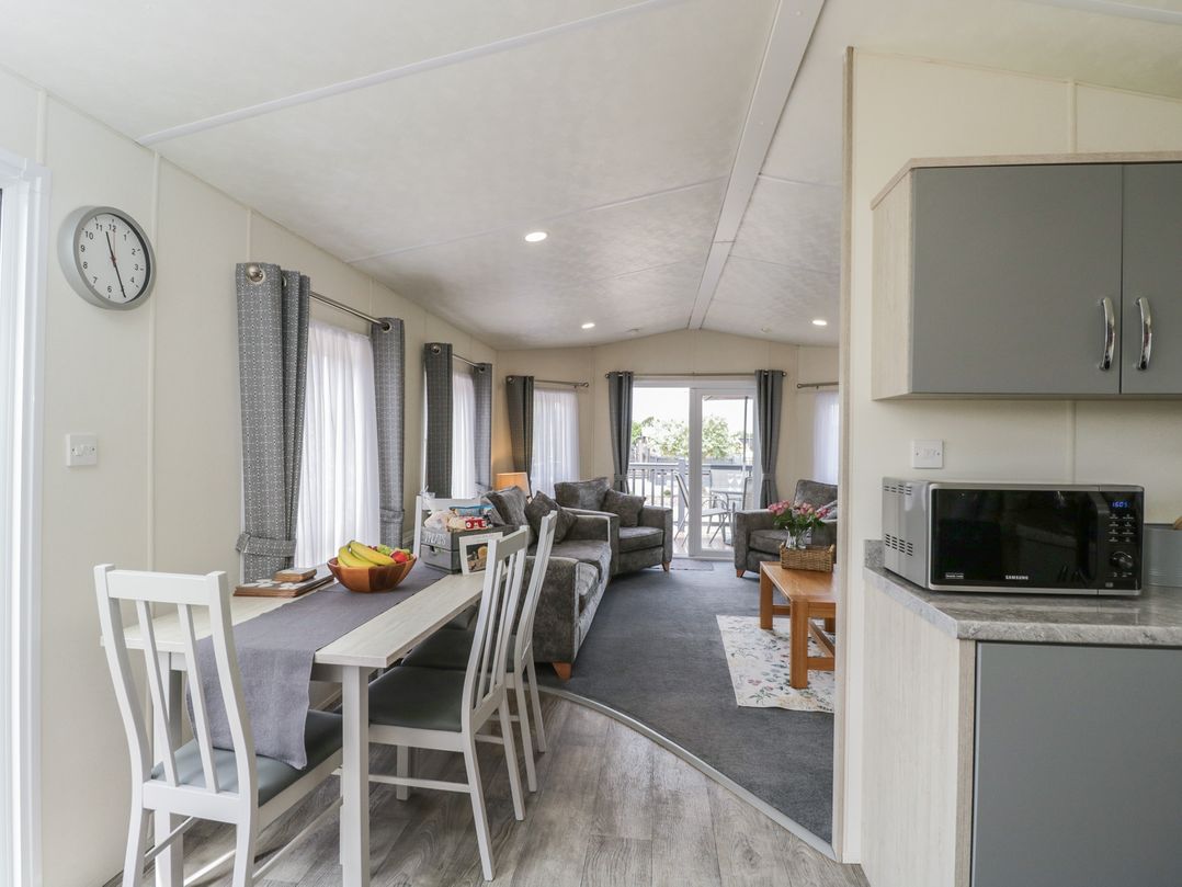 A living room with furniture and dining area at The Cotswold Holiday Lodge in Evesham