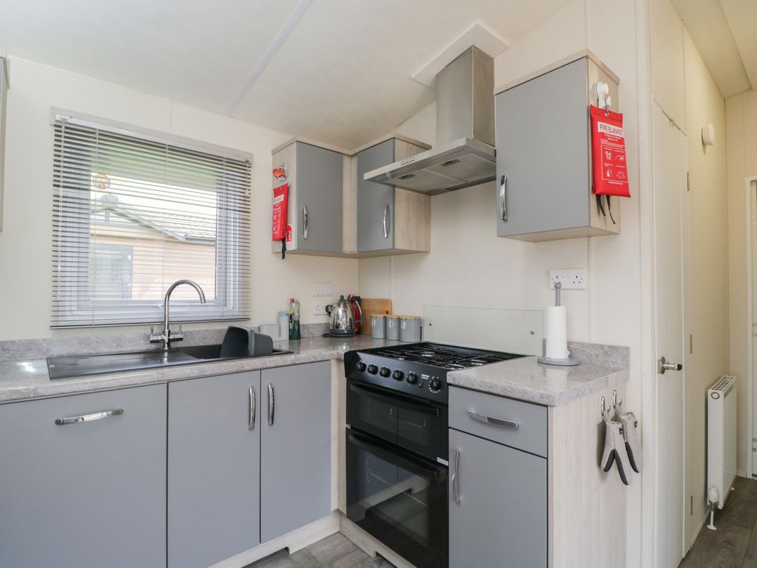 A kitchen with cabinets and an oven at The Cotswold Holiday Lodge in Evesham