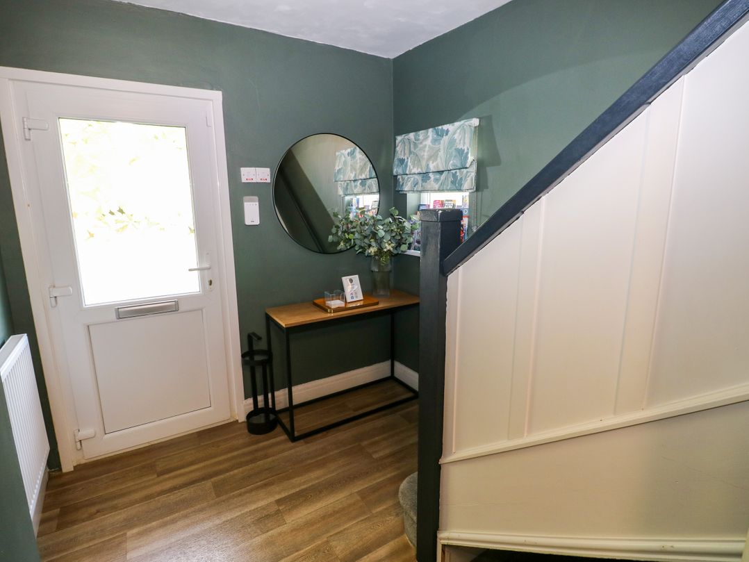 A hallway with a console table and mirror at Teifi Villa in St Dogmaels