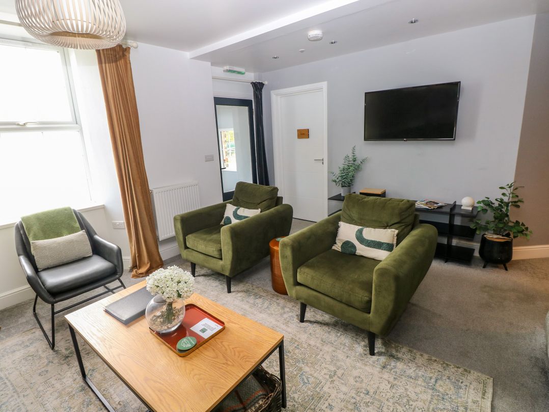 A living room with armchairs and a coffee table at Teifi Villa in St Dogmaels