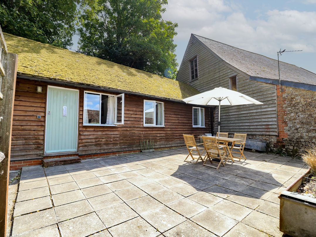 An outdoor patio with table and chairs at Byre Cottage 2 Sullington near Storrington