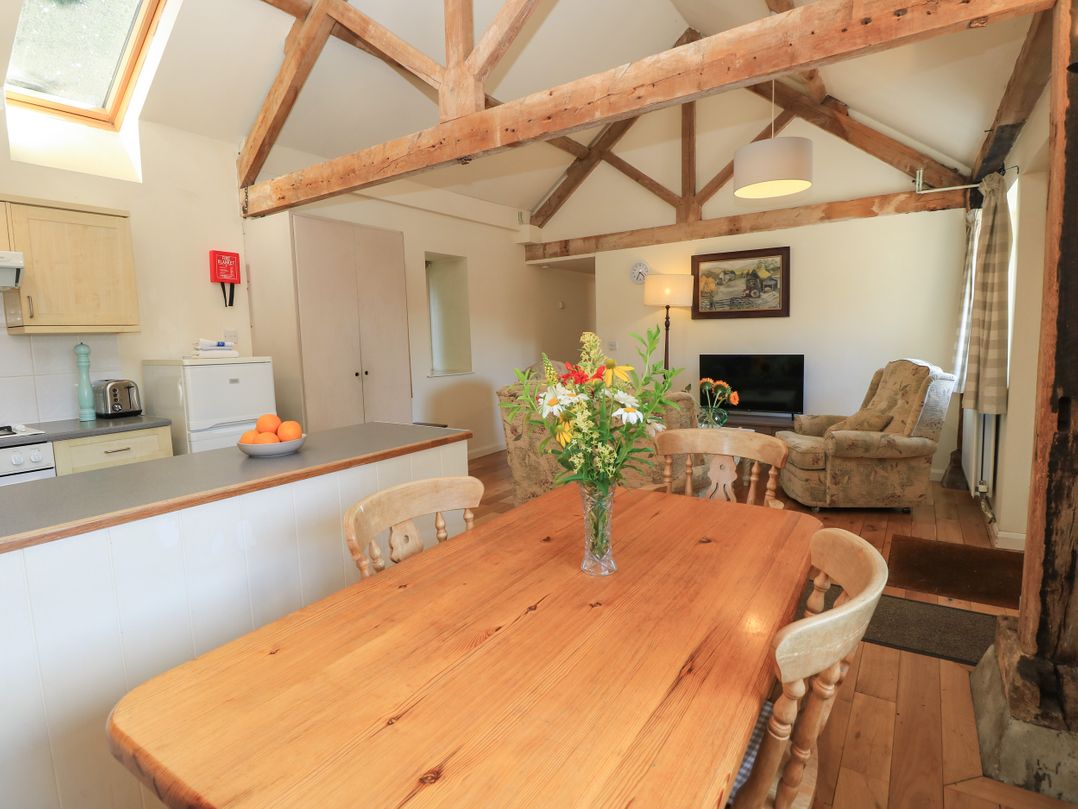 A dining room with a table and chairs at Byre Cottage 2 in Sullington near Storrington