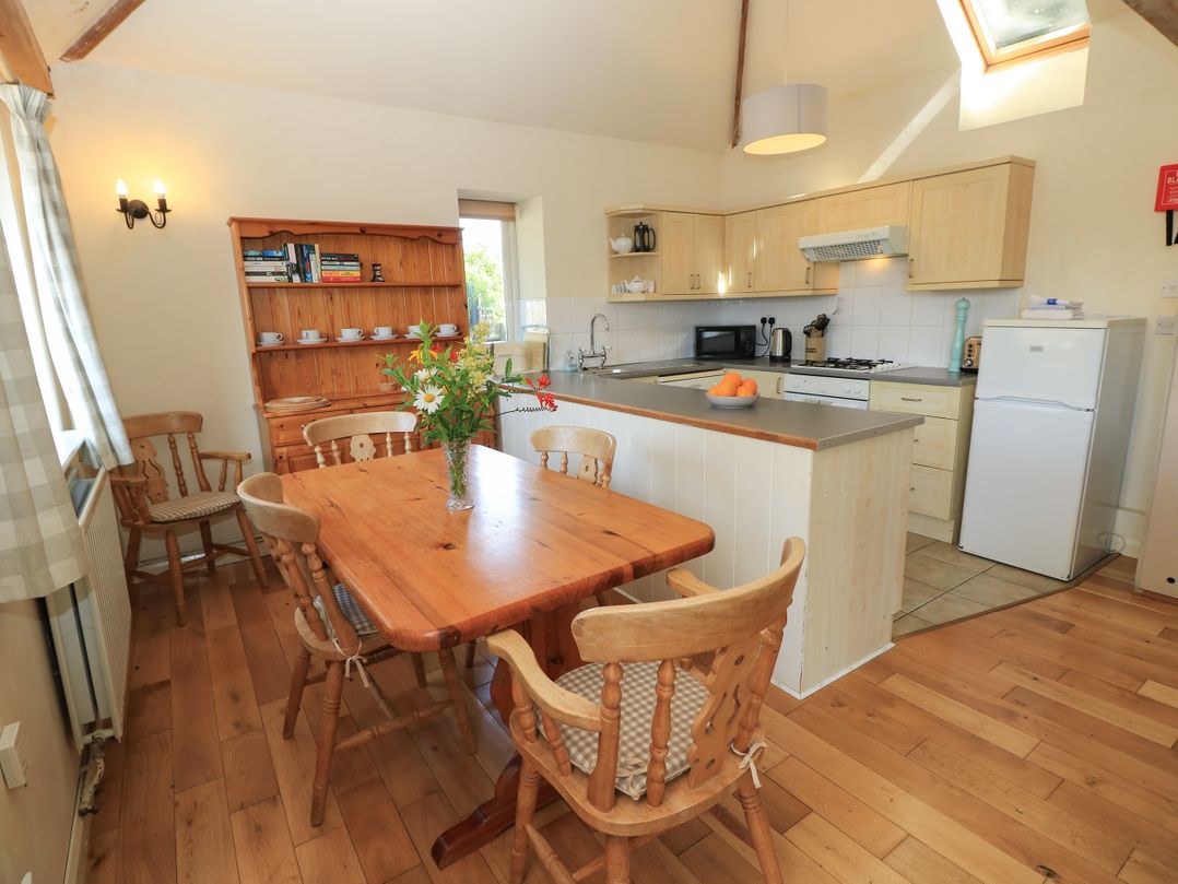 A kitchen with a wooden table and chairs at Byre Cottage 2 Sullington near Storrington