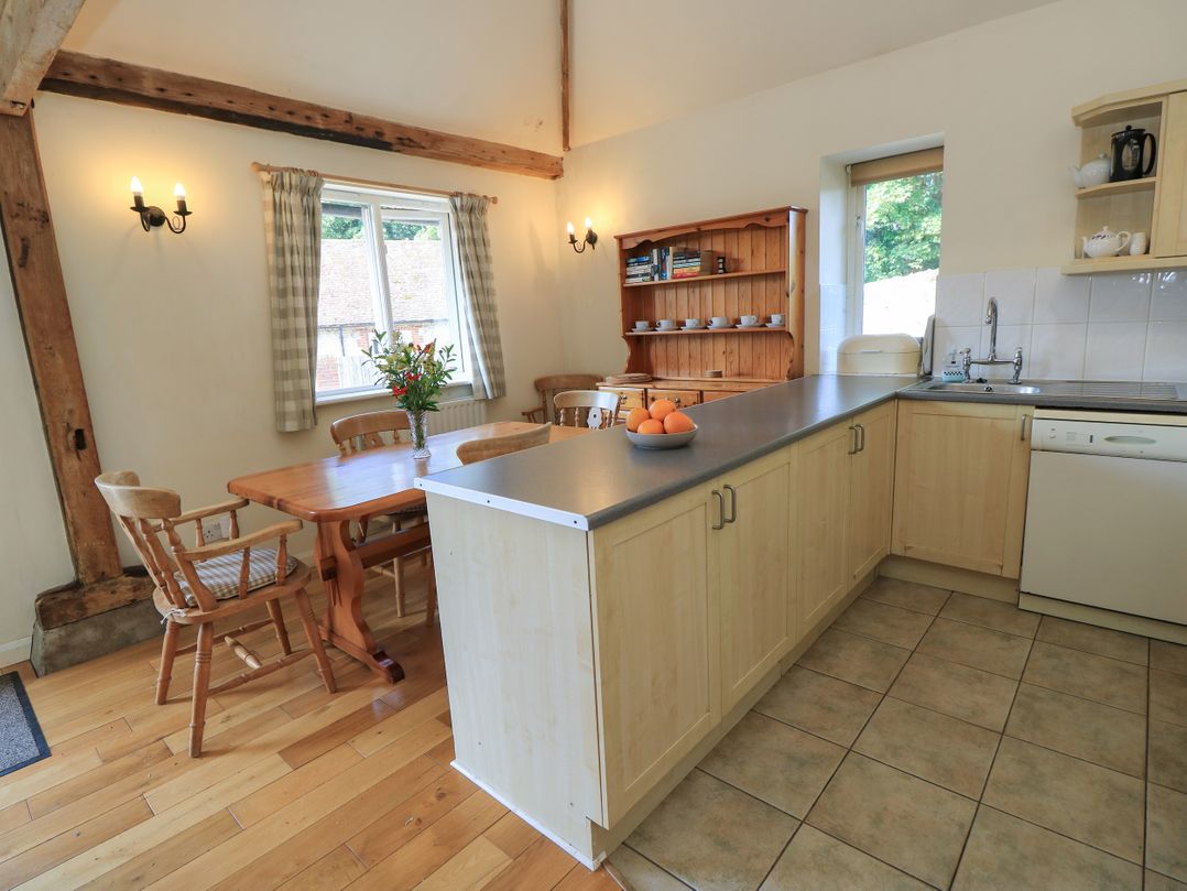 A kitchen with a dining table and chairs at Byre Cottage 2 Sullington near Storrington