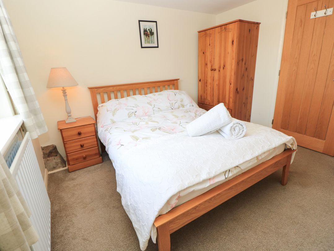 A bedroom with a bed and bedside table at Byre Cottage 2 Sullington near Storrington