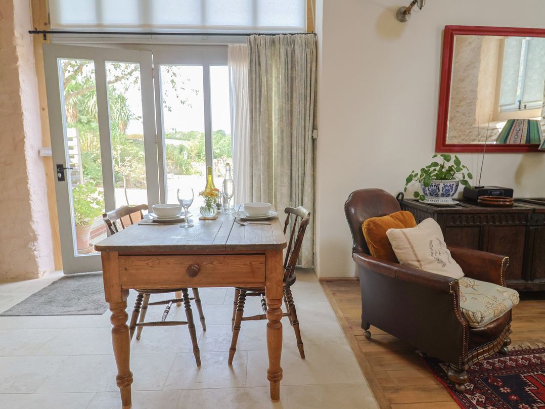 A dining room with a table and chairs at The Stone Barn in Bridport