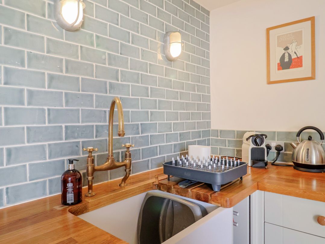 A kitchen with a sink, tap, and appliances at The Stone Barn in Bridport