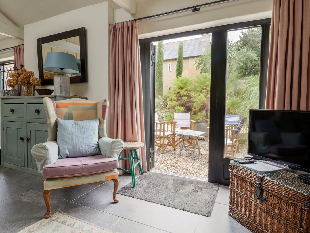 A living room with a chair and table at The Dairy in Bridport