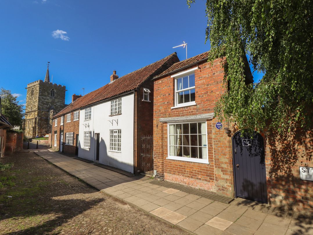 A street view featuring houses and a church at Hangmans cottage Horncastle