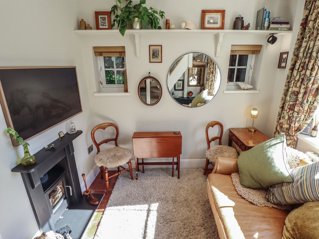 A living room with a mirror and sofa at Hangmans cottage in Horncastle