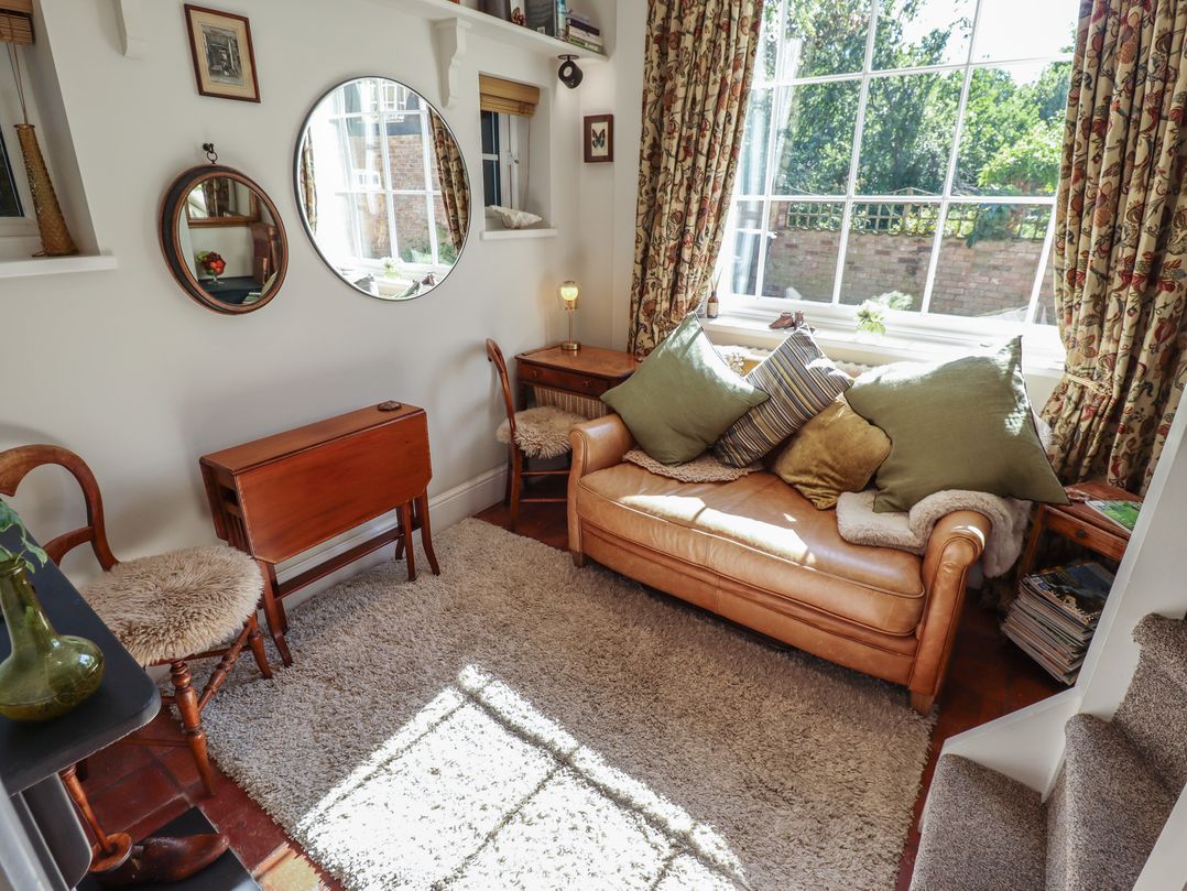 A living room with a sofa and mirror at Hangmans cottage Horncastle