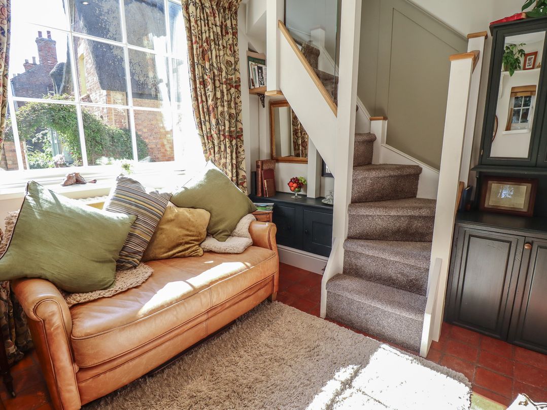 A living room with a sofa and staircase at Hangmans cottage in Horncastle