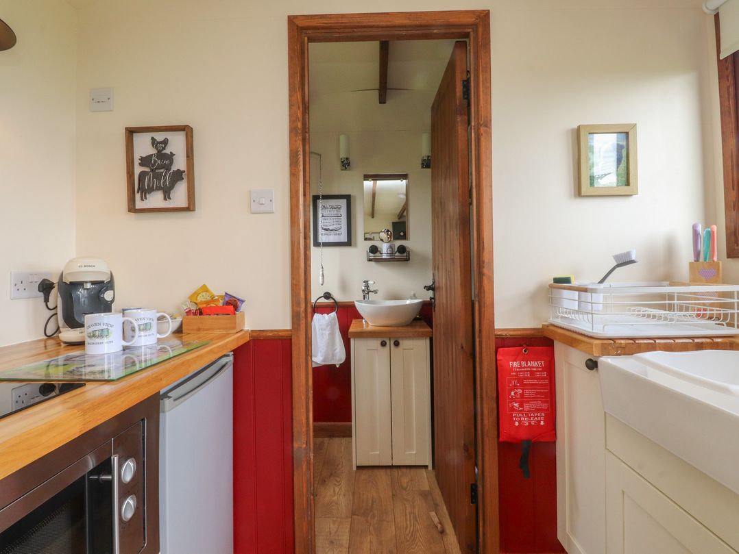 A kitchen with a sink and coffee maker at The Herdsman Luxury Shepherds Hut Barnoldswick