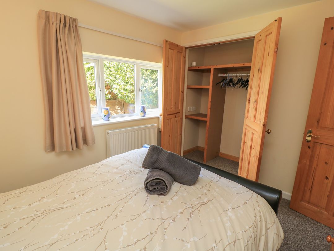A bedroom with a bed and wardrobe at Ryecross Farm Cottage in Shaftesbury
