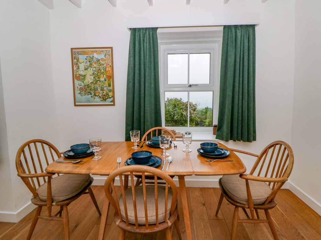 A dining room with a wooden table set for dinner at Ceunant near Newport